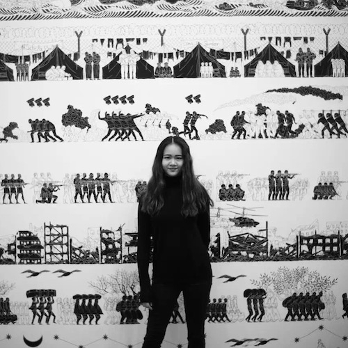 Siyue Wang stands in front of mural